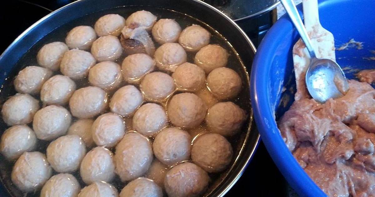 Proses pembuatan bakso sapi rumahan dengan adonan di baskom biru dan bakso direbus dalam panci besar berisi air panas