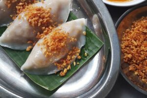 Tiga buah choipan isi bengkuang dan kucai disajikan di atas daun pisang dalam nampan logam, ditaburi bawang goreng renyah